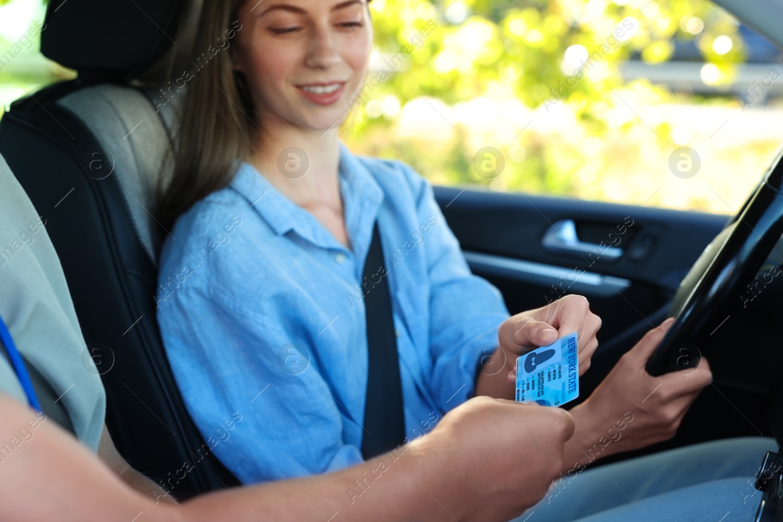 Photo of Driving school. Examiner giving driving license to student after exam in car, selective focus