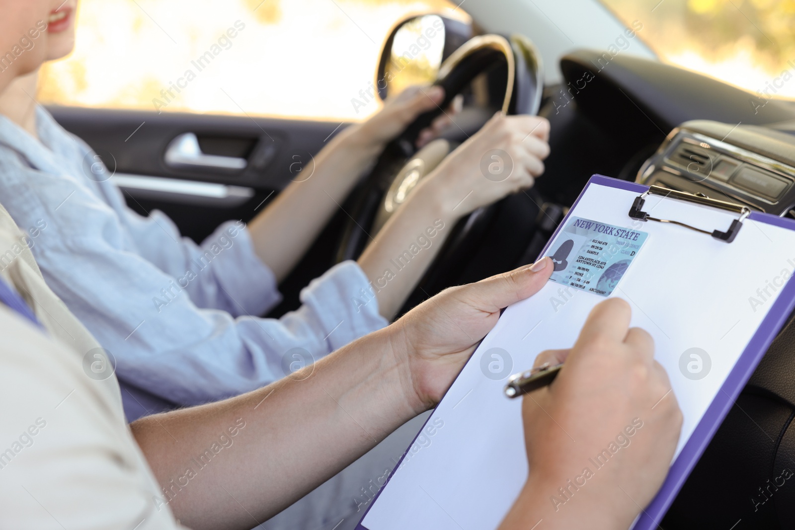 Photo of Driving school. Student passing driving test with examiner in car, closeup