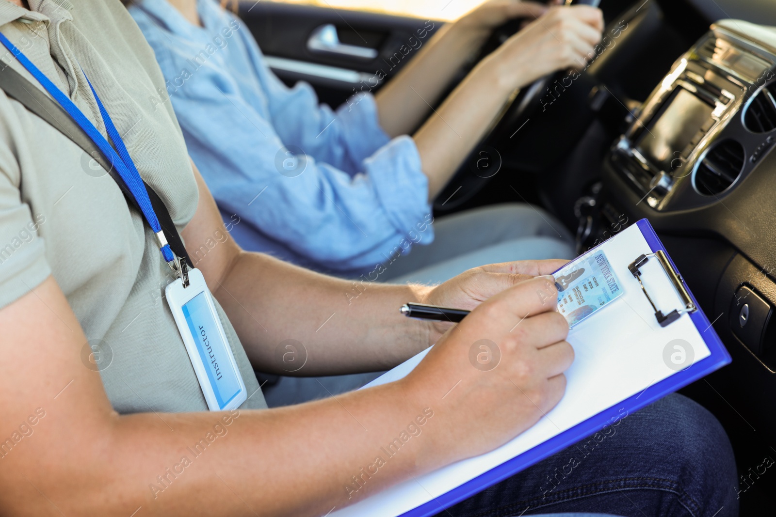 Photo of Driving school. Student passing driving test with examiner in car, closeup