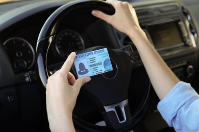 Photo of Driving school. Woman with driving license in car, closeup