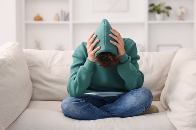 Loneliness concept. Sad teenage boy on sofa at home