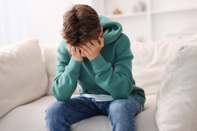 Photo of Loneliness concept. Sad teenage boy on sofa at home