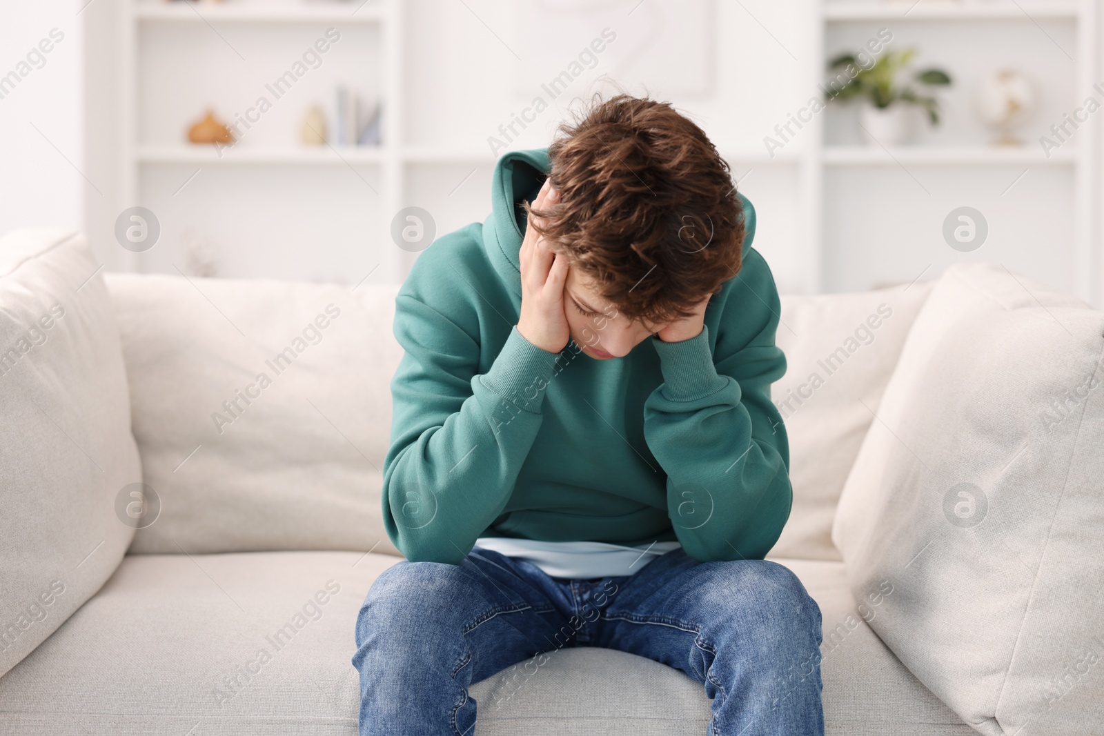 Photo of Loneliness concept. Sad teenage boy on sofa at home