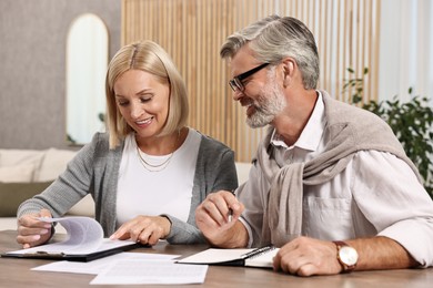 Couple planning pension budget at table indoors