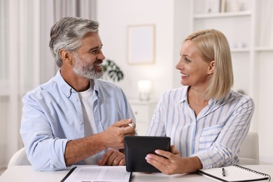 Photo of Pension savings. Couple planning budget at table indoors