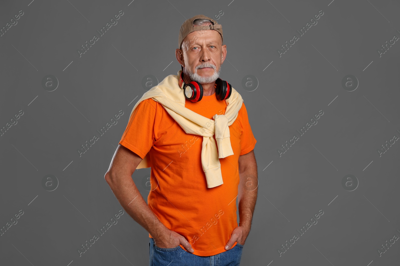 Photo of Portrait of handsome senior man with headphones on grey background