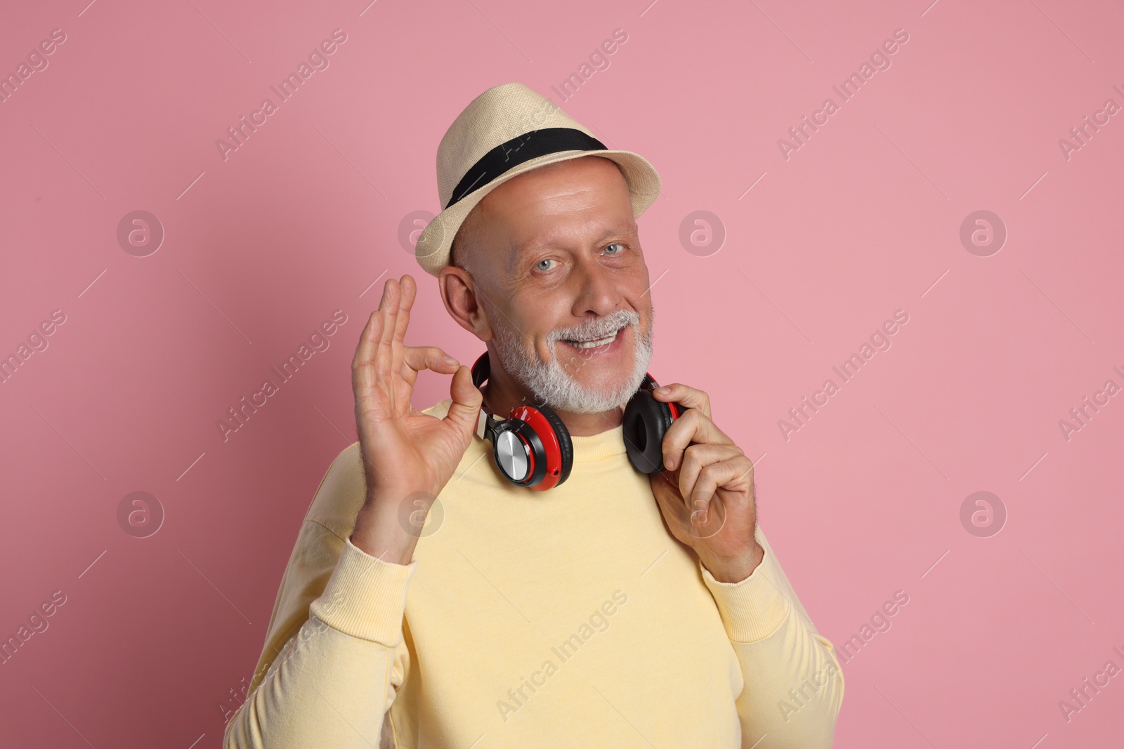 Photo of Portrait of happy senior man showing ok gesture on pink background