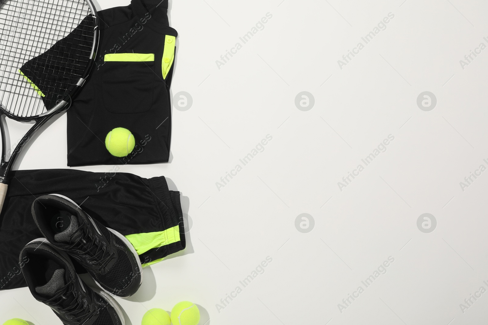 Photo of Tennis racket, balls and sportswear on white background, flat lay. Space for text