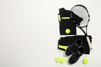 Photo of Tennis racket, balls and sportswear on white background, flat lay. Space for text