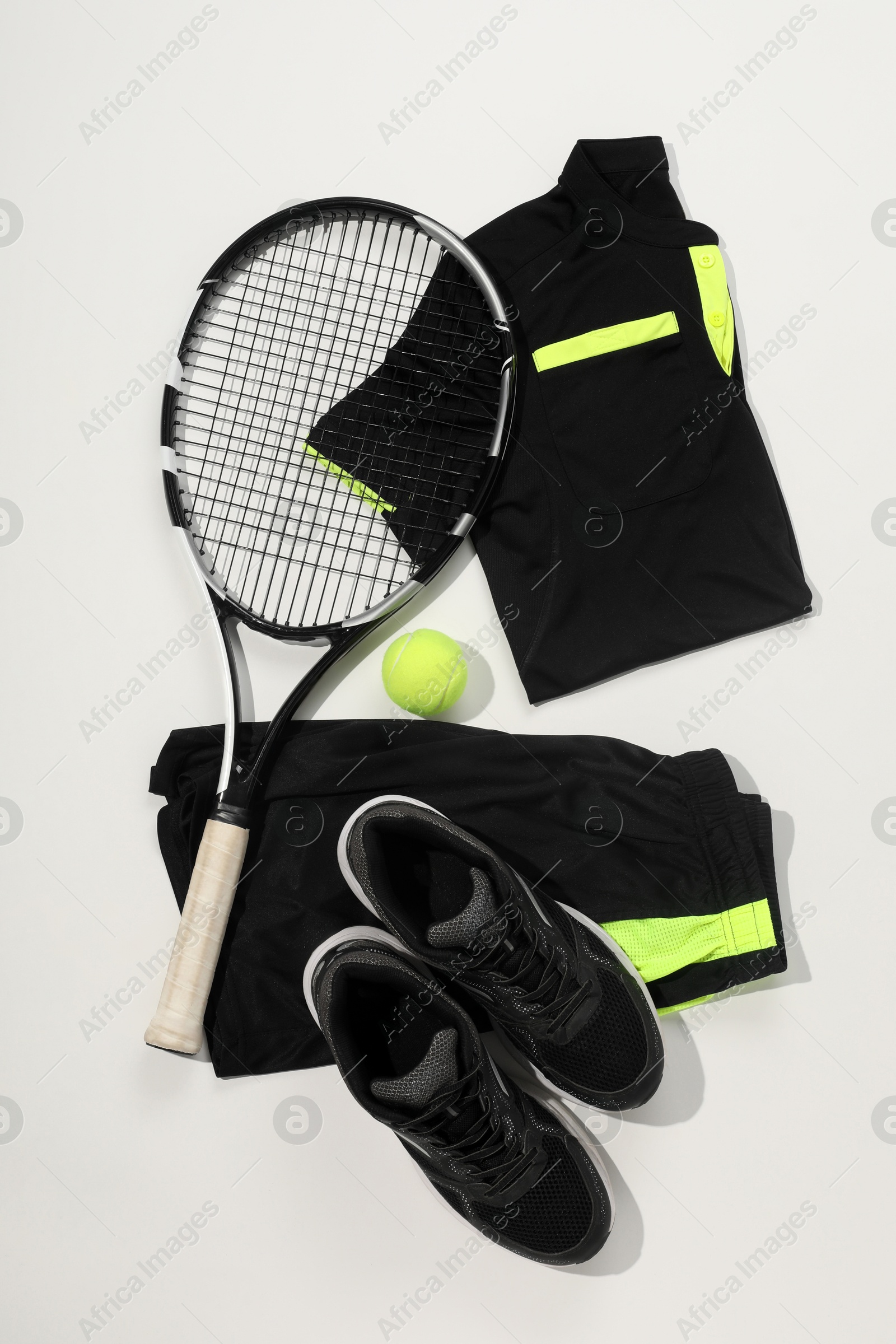 Photo of Tennis racket, ball and sportswear on white background, flat lay