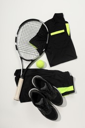 Photo of Tennis racket, ball and sportswear on white background, flat lay