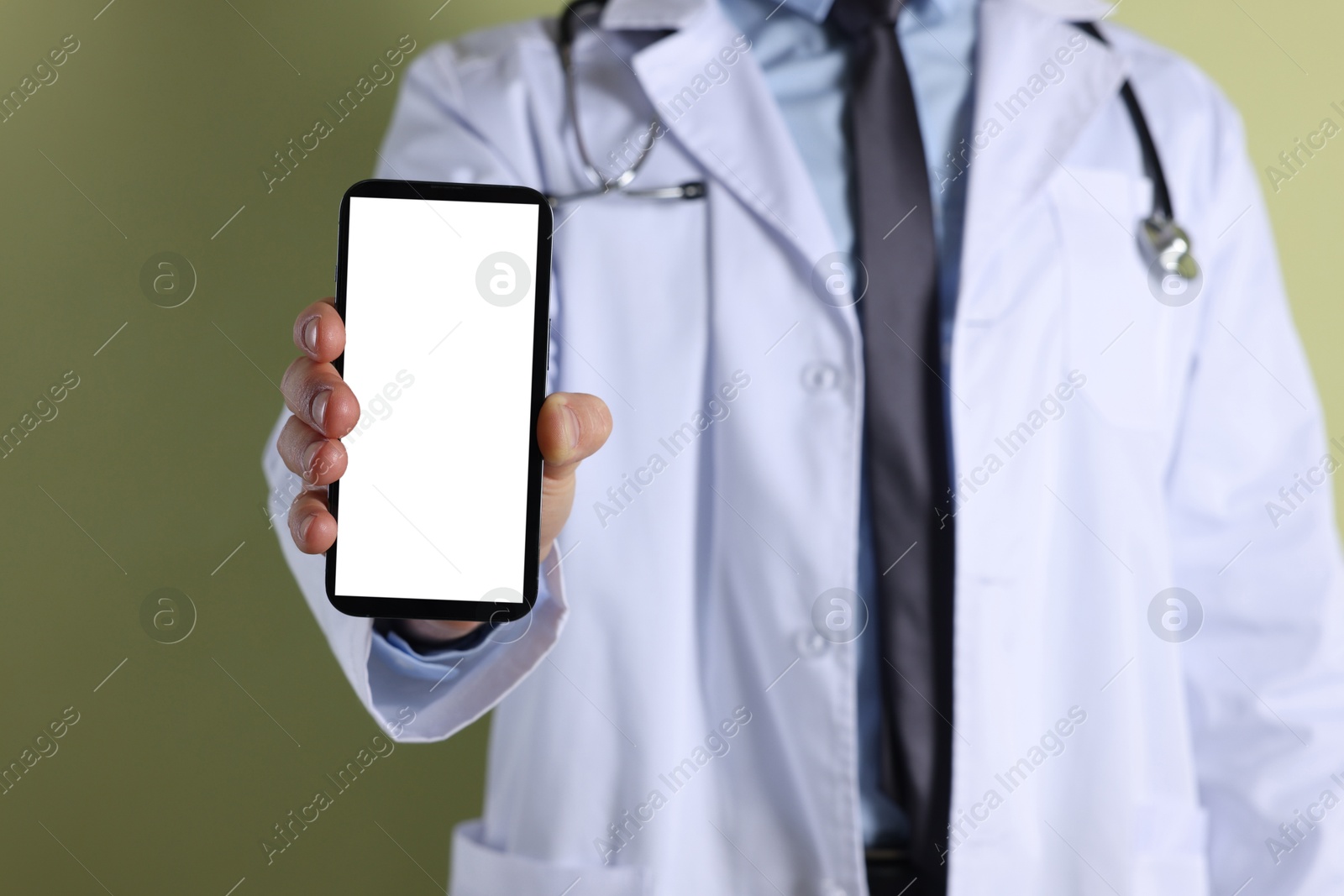 Photo of Doctor showing smartphone with blank screen on olive background, closeup. Mockup for design