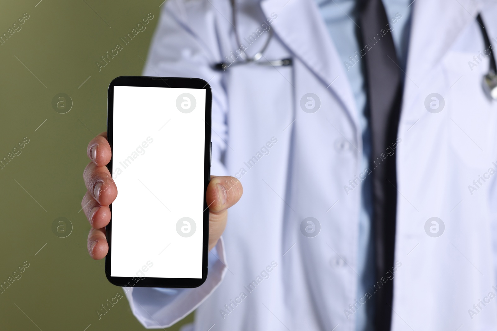 Photo of Doctor showing smartphone with blank screen on olive background, closeup. Mockup for design