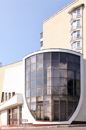 Photo of Modern building with big windows against blue sky outdoors