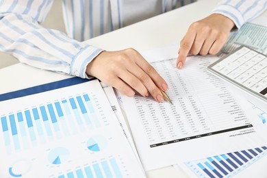 Budget planning. Woman with papers at white table, closeup