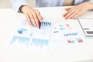 Budget planning. Woman with papers at white table, closeup