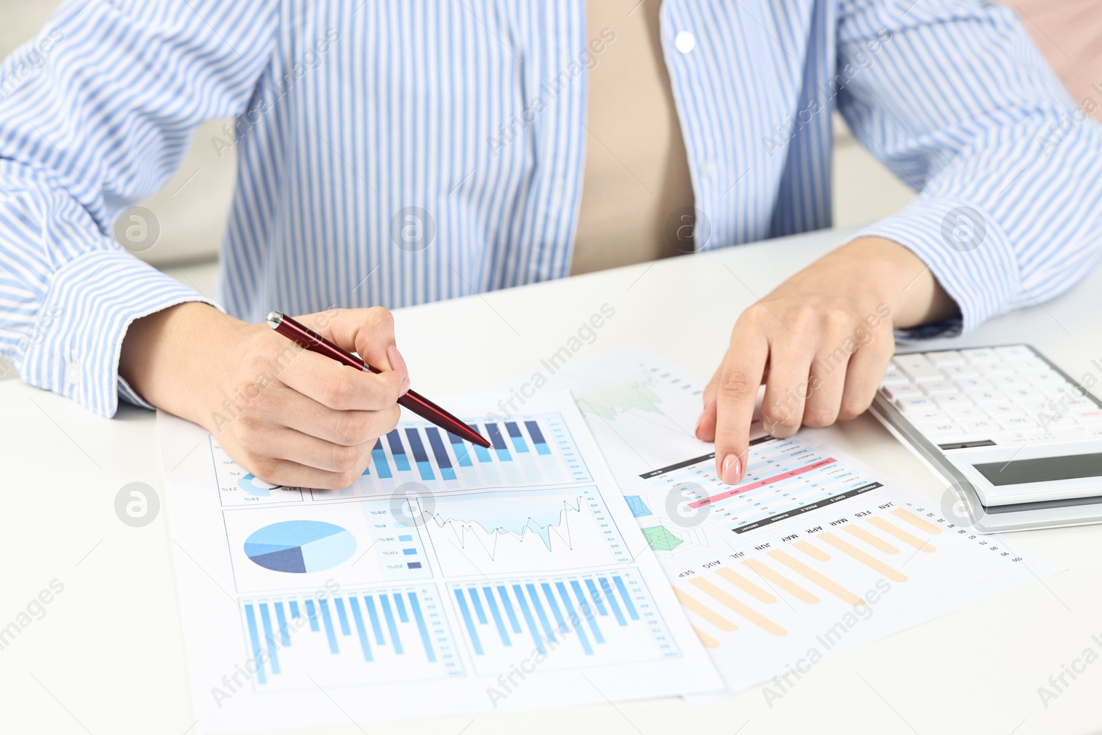 Photo of Budget planning. Woman with papers and calculator at white table, closeup