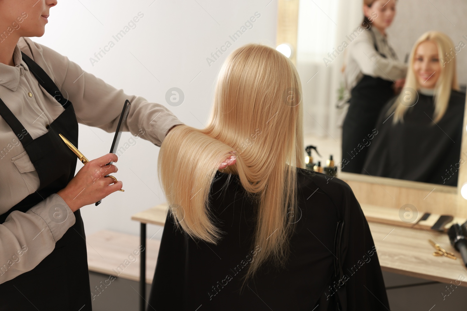 Photo of Hair cutting. Professional hairdresser working with client in salon, closeup