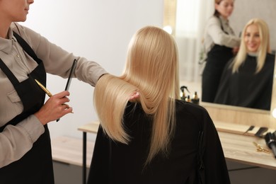 Photo of Hair cutting. Professional hairdresser working with client in salon, closeup