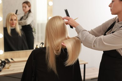 Hair cutting. Professional hairdresser working with client in salon