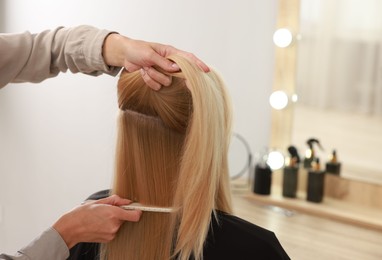 Photo of Hair cutting. Professional hairdresser working with client in salon, closeup