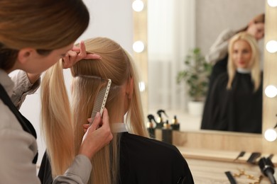 Hair cutting. Professional hairdresser working with client in salon