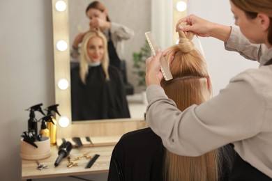 Photo of Hair cutting. Professional hairdresser working with client in salon