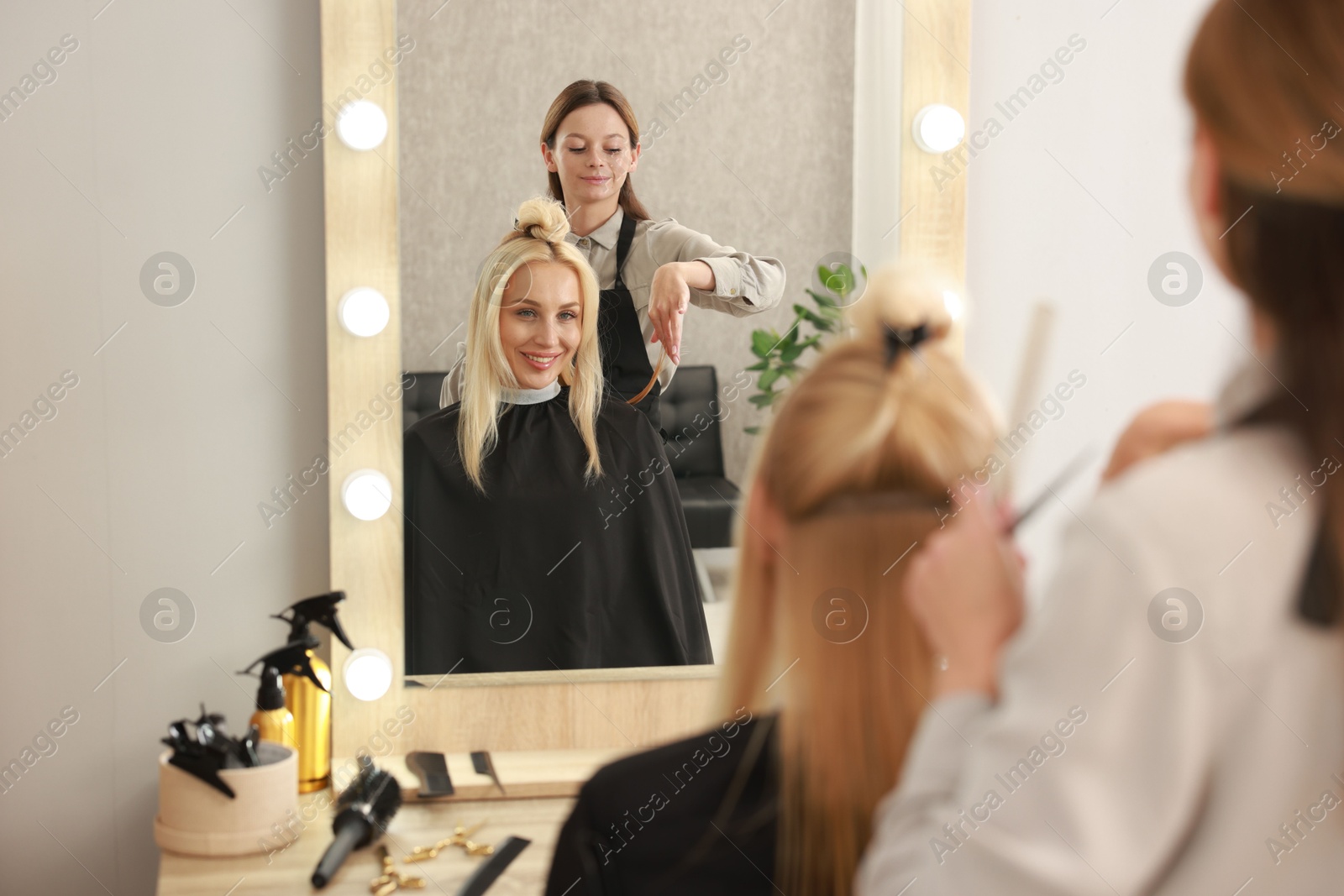 Photo of Hair cutting. Professional hairdresser working with client in salon, selective focus