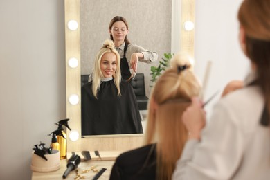 Hair cutting. Professional hairdresser working with client in salon, selective focus