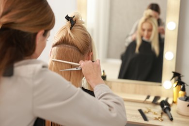 Photo of Hair cutting. Professional hairdresser working with client in salon