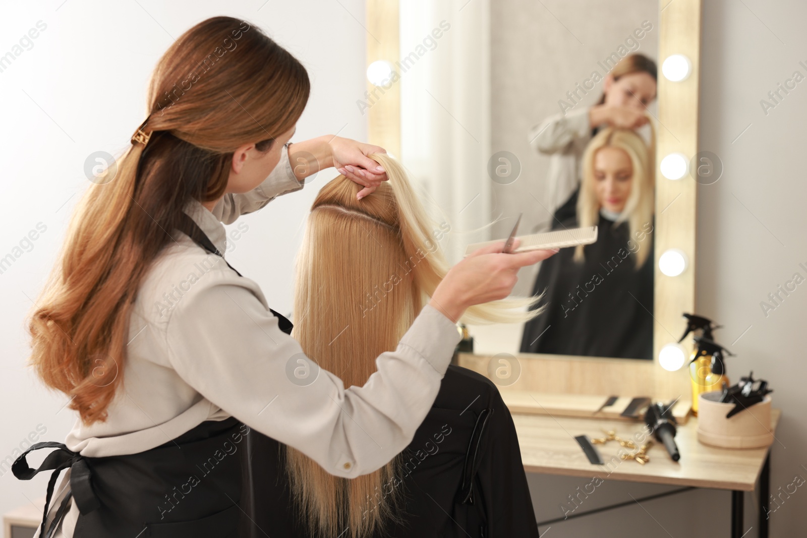 Photo of Hair cutting. Professional hairdresser working with client in salon