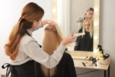 Hair cutting. Professional hairdresser working with client in salon