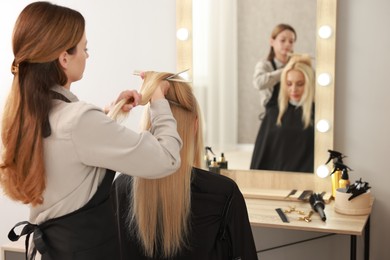 Photo of Hair cutting. Professional hairdresser working with client in salon