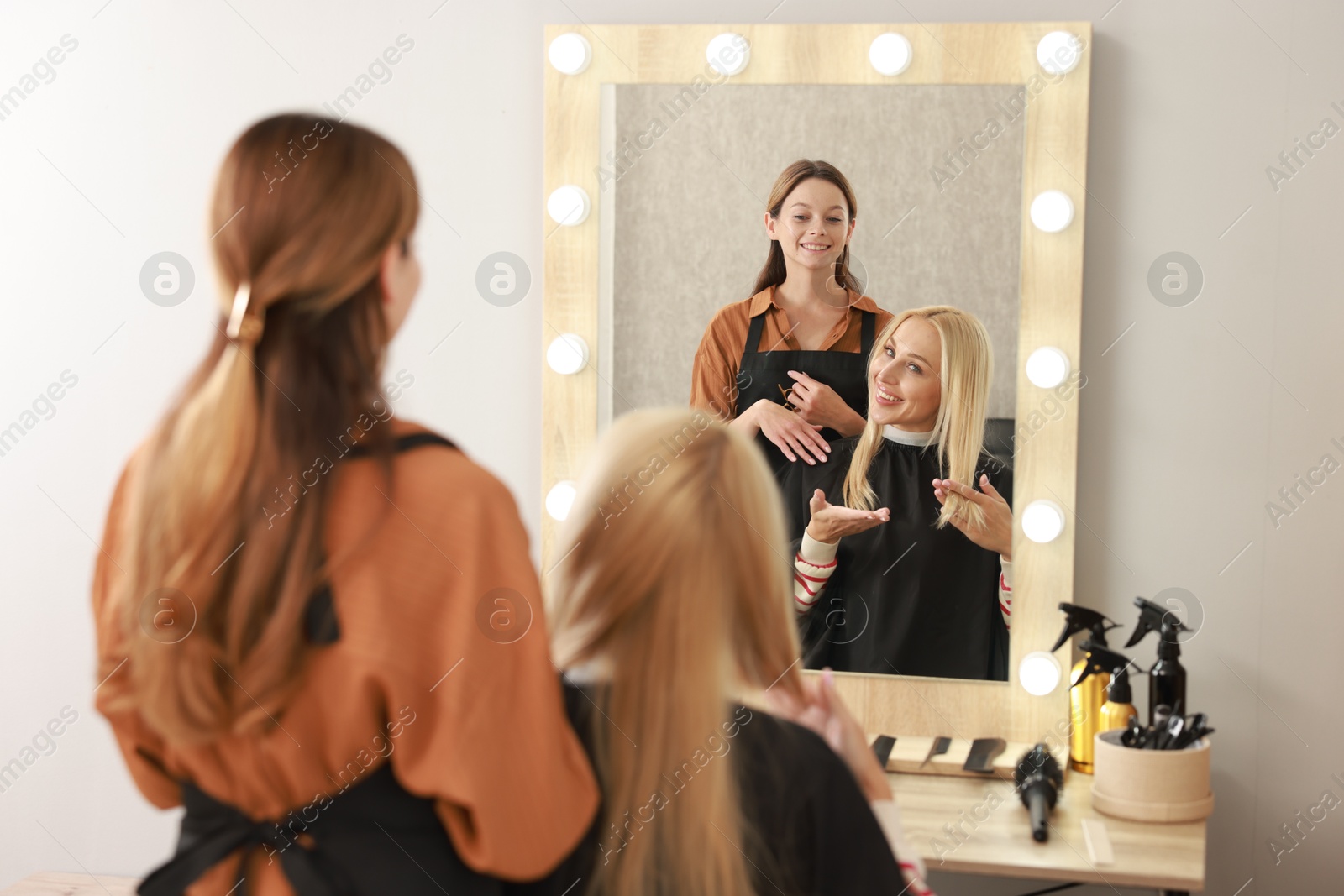 Photo of Hair cutting. Professional hairdresser working with client in salon, selective focus