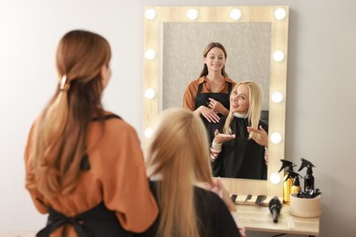 Hair cutting. Professional hairdresser working with client in salon, selective focus