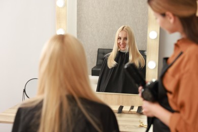 Photo of Hair cutting. Professional hairdresser working with client in salon, selective focus