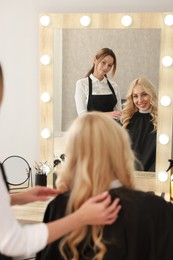 Photo of Hair cutting. Professional hairdresser working with client in salon, selective focus