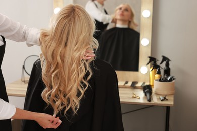 Hair cutting. Professional hairdresser working with client in salon, closeup