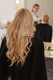 Photo of Hair cutting. Professional hairdresser working with client in salon, closeup