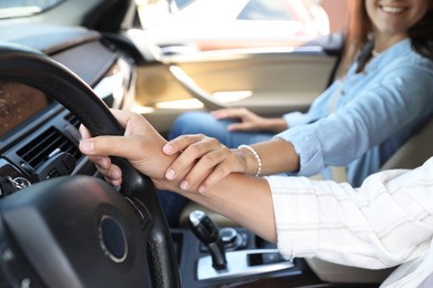 Lovely couple holding hands together while traveling by car, closeup