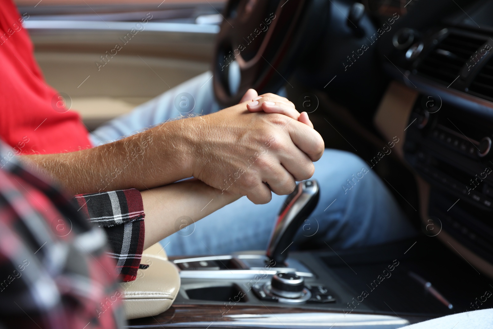 Photo of Lovely couple holding hands together while traveling by car, closeup