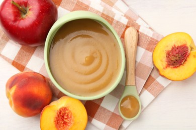 Photo of Delicious baby food in bowl and fresh ingredients on white wooden table, flat lay