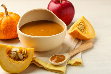 Photo of Delicious baby food in bowl and fresh ingredients on white wooden table