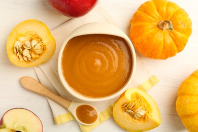 Photo of Delicious baby food in bowl and fresh ingredients on white wooden table, flat lay