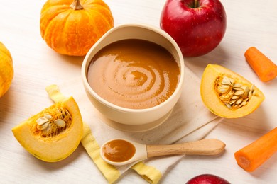 Photo of Delicious baby food in bowl and fresh ingredients on white wooden table