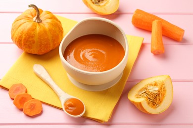 Photo of Delicious baby food in bowl and fresh ingredients on pink wooden table