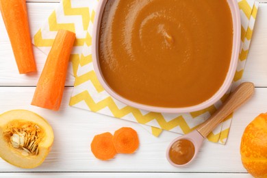 Photo of Delicious baby food in bowl and ingredients on white wooden table, flat lay