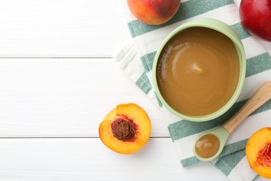 Photo of Delicious baby food in bowl and ingredients on white wooden table, flat lay. Space for text