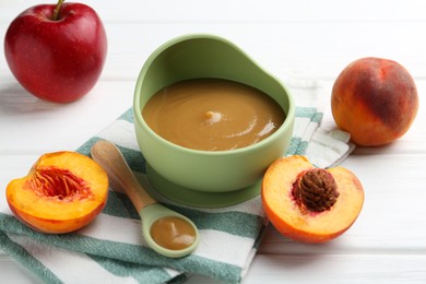 Photo of Delicious baby food in bowl and ingredients on white wooden table