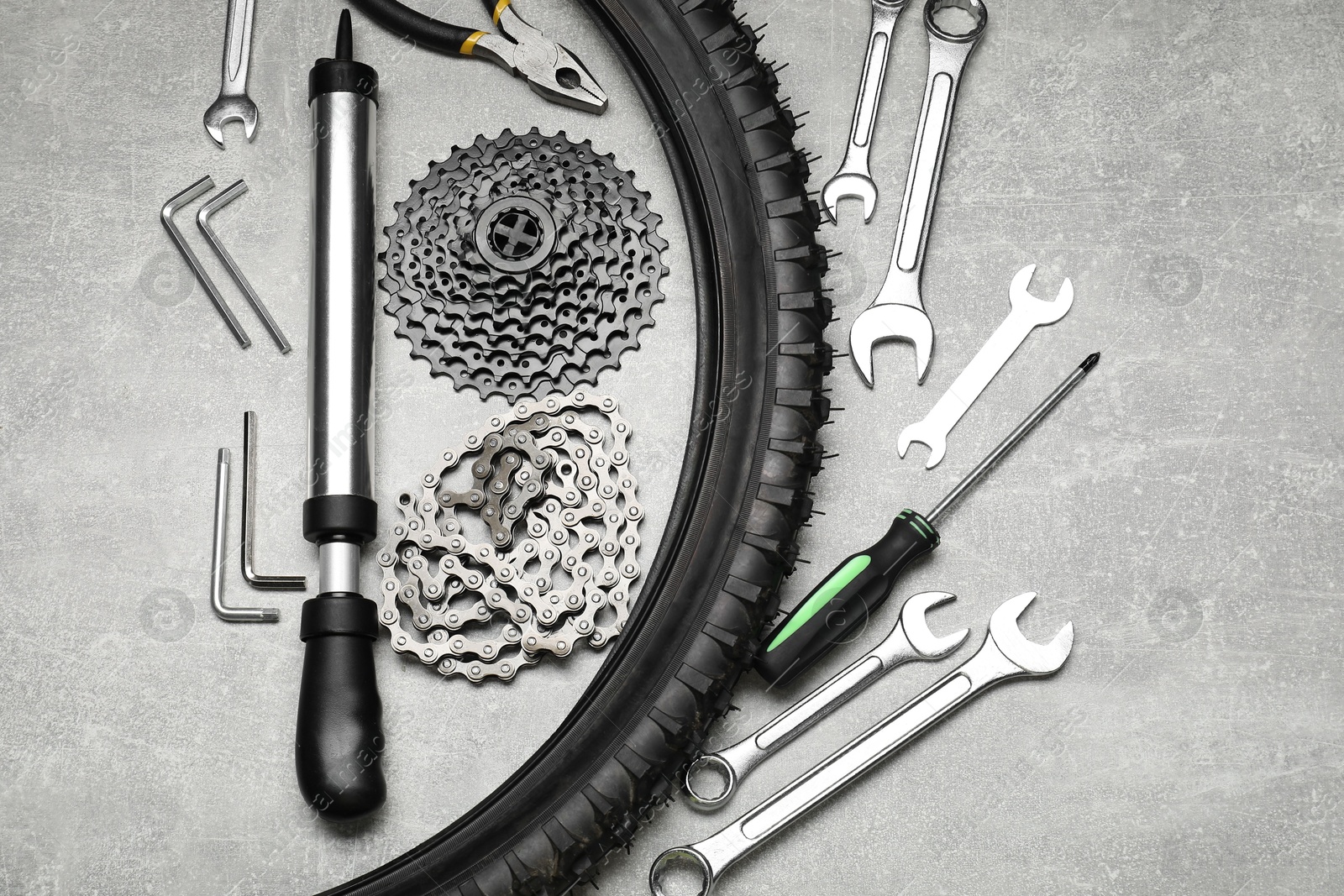 Photo of Parts of bicycle and tools on light grey table, flat lay